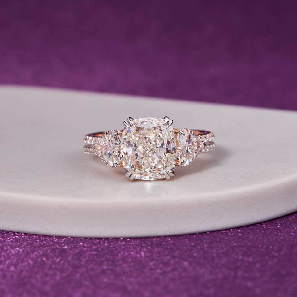 3.00 CT cushion-cut diamond, beautifully complemented by two heart-shaped side diamonds ring